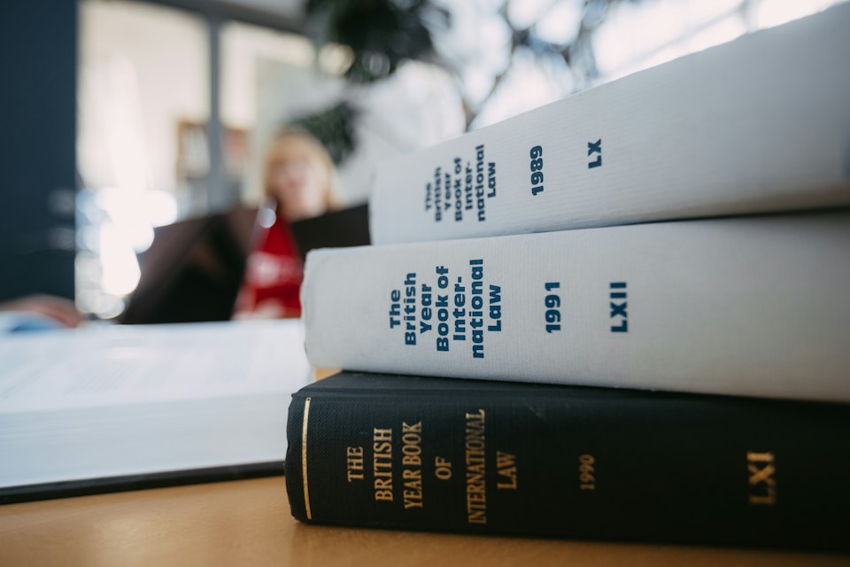Livros de referência jurídica empilhados sobre uma mesa