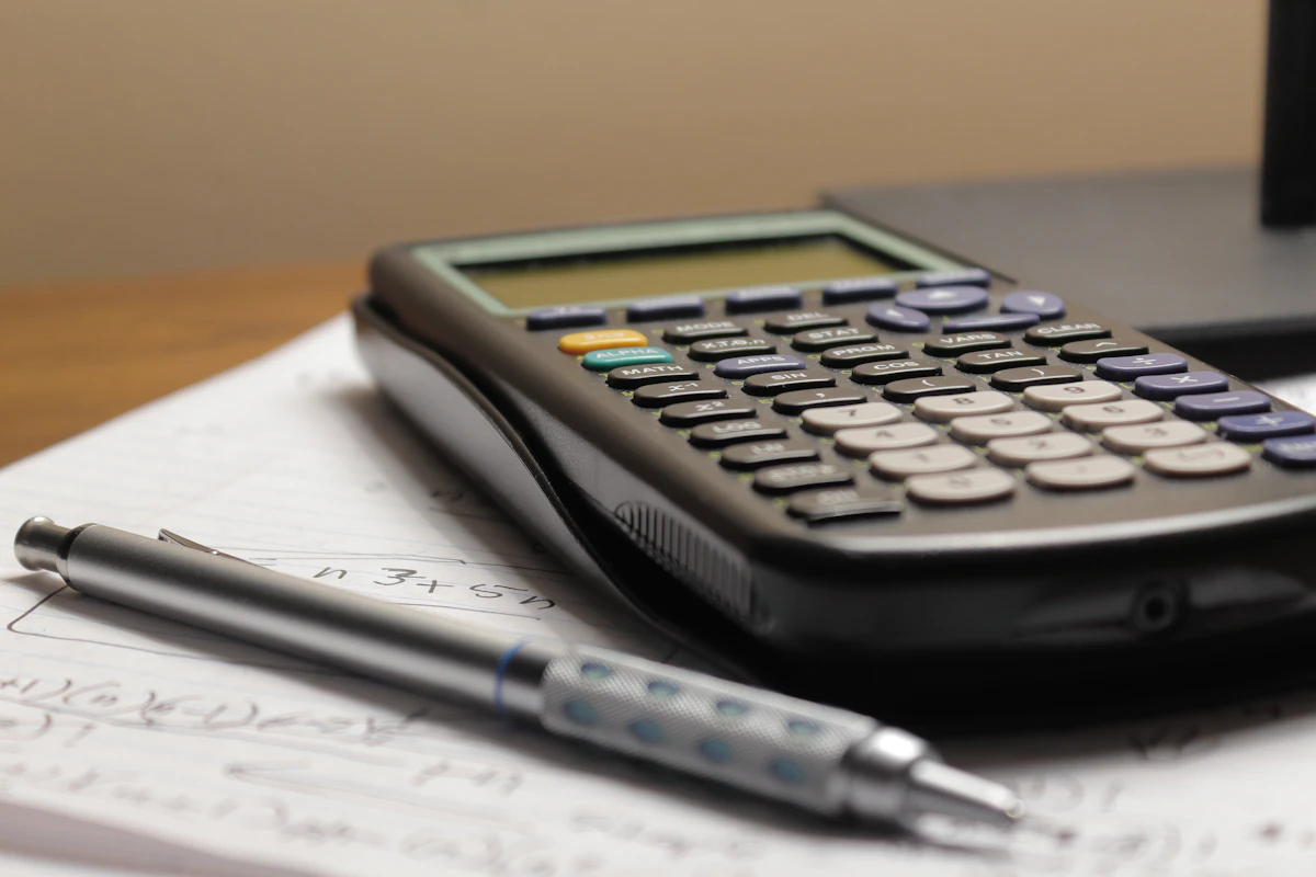 Calculadora e caneta sobre relatório financeiro