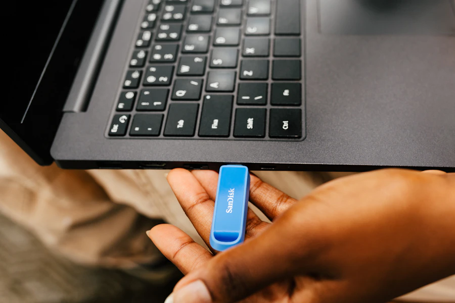 Mão conectando um pen drive de backup ao notebook